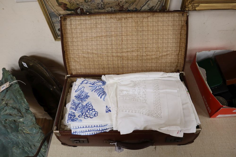 A quantity of mixed table linens in a suitcase